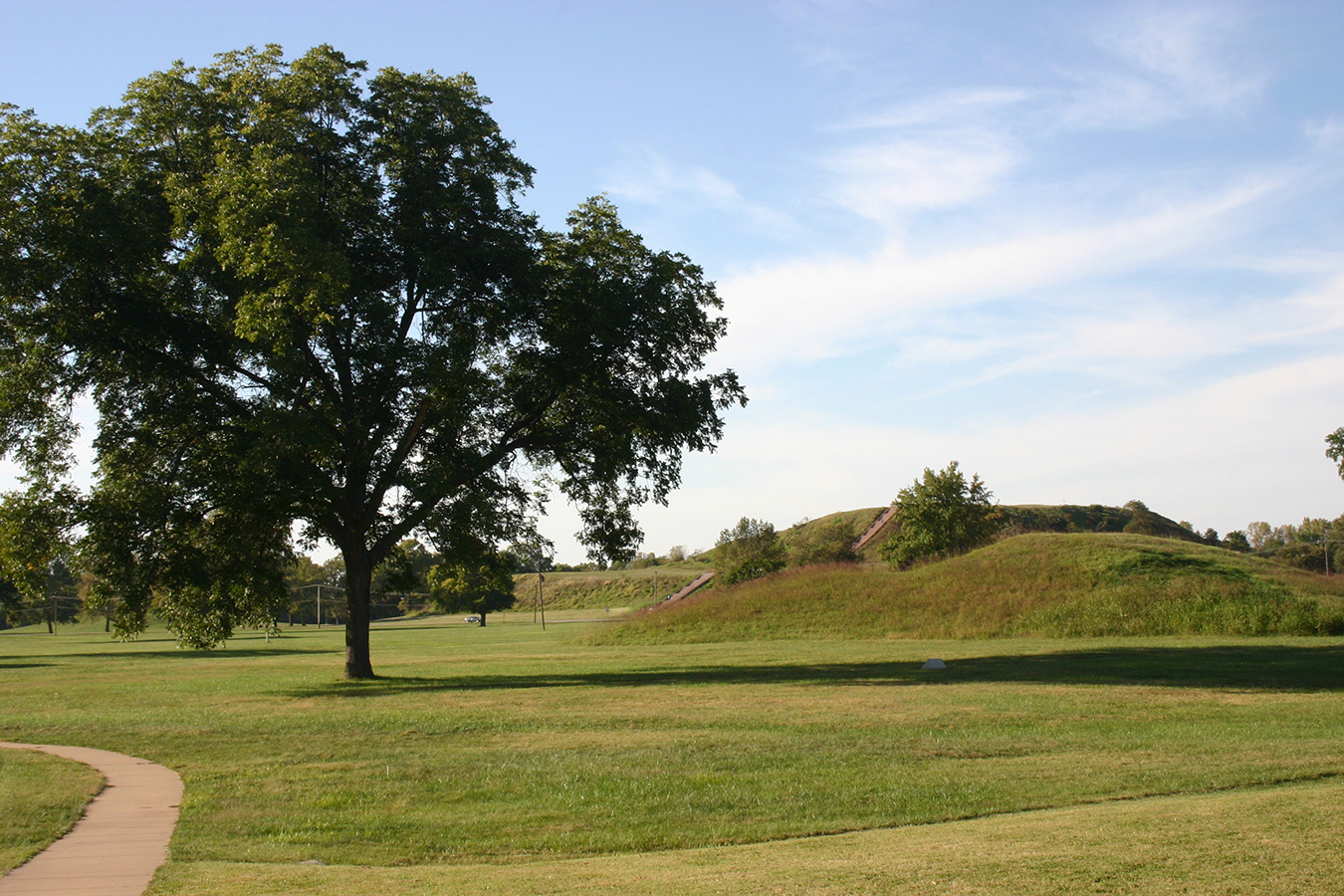 Monks Mound behind a smaller mound at Cahokia. Note the car and telephone poles near the mound for scale. Photo by Leigh Bloch.