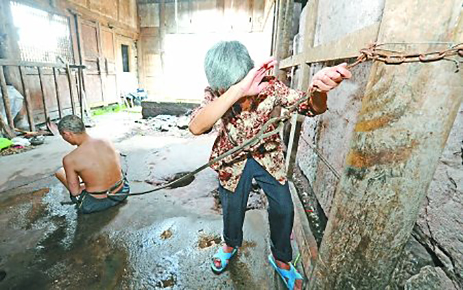 A forty-year-old patient restrained with chains by her mother for twenty-three years. Photo by Zhibing Zhong. http://health.sohu.com/20110825/n352889530.shtml.