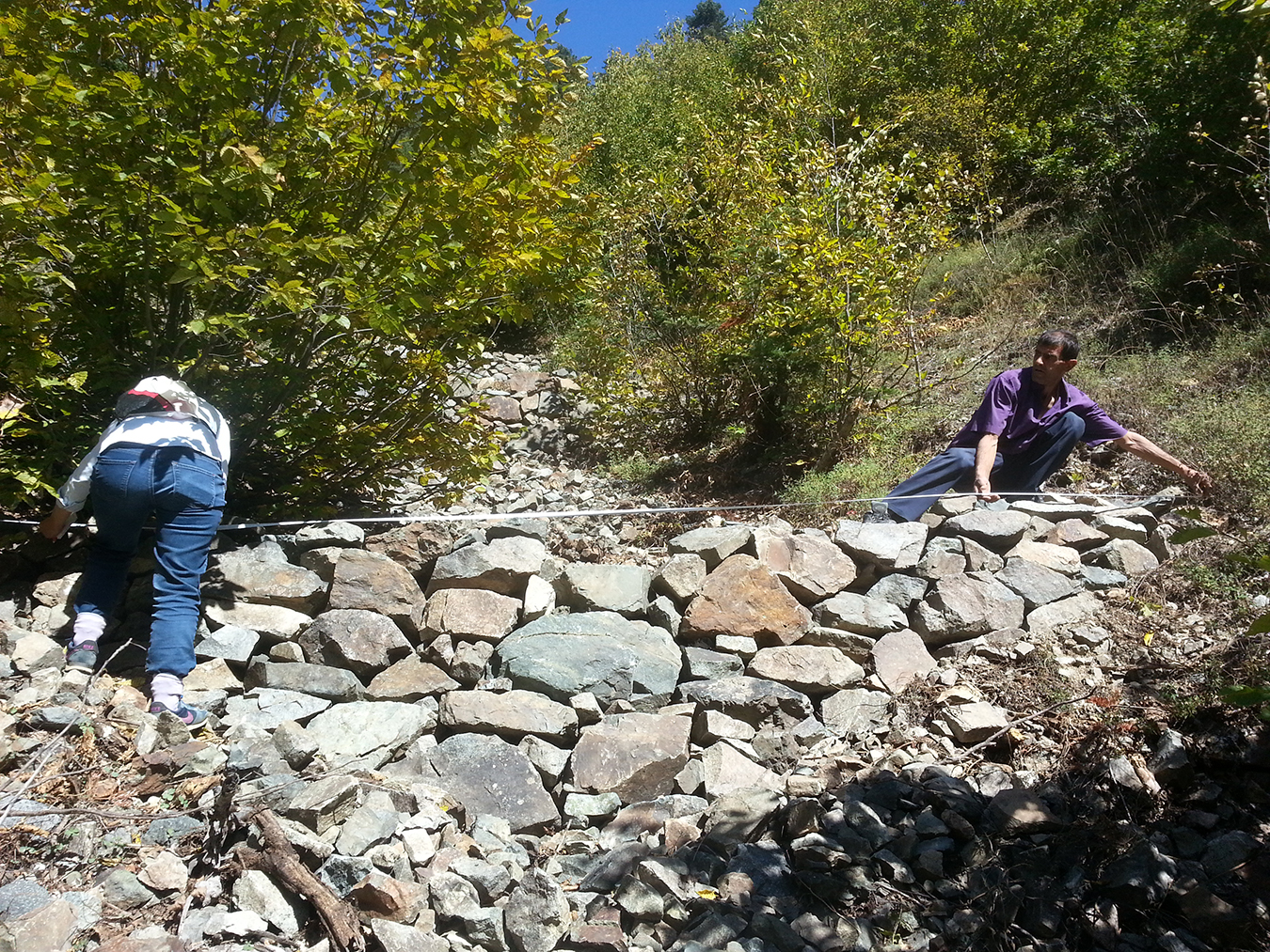 A forester and a villager are measuring the erosion control walls built in Gudashev within the scope of the watershed rehabilitation project. Photo by Ekin Kurtiç.