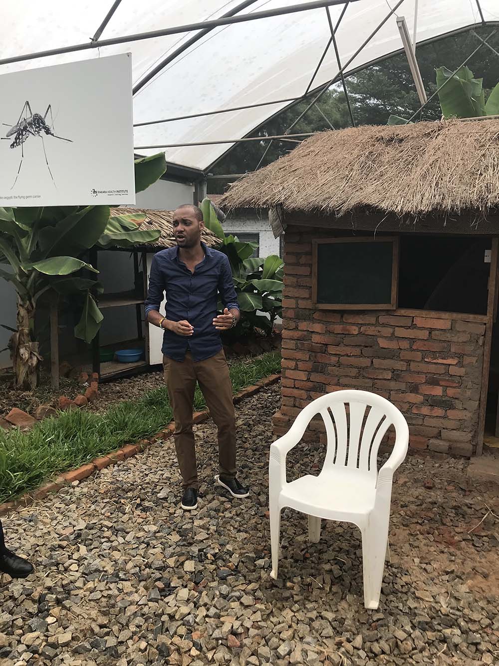 Arnold Mmbando, describing the operation of eave ribbons attached to an experimental hut, January 2020. Photo by Ann H. Kelly and Javier Lezaun.