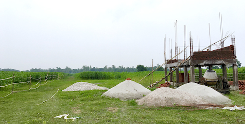 A concrete watchtower in a field.